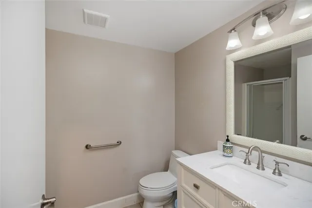a bathroom with a granite countertop sink a toilet and a mirror