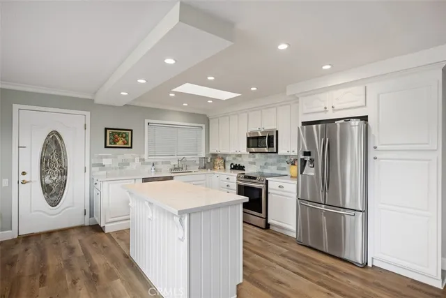 a kitchen with stainless steel appliances granite countertop a refrigerator a stove a sink and a oven