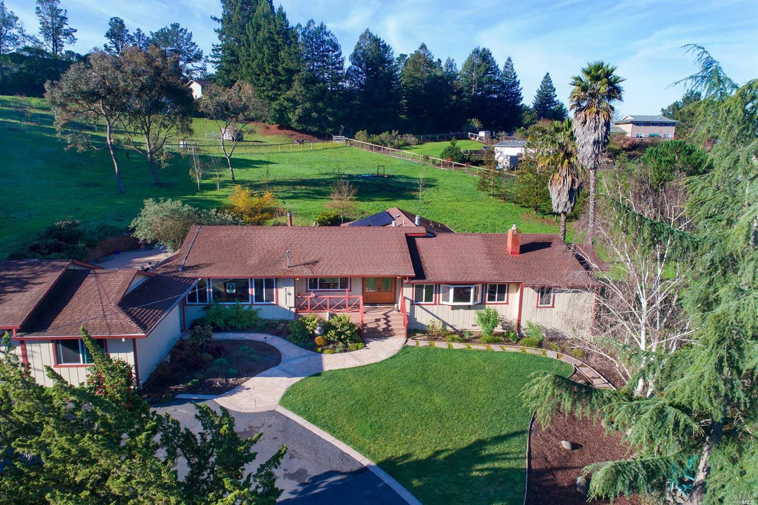 an aerial view of a house with yard and green space
