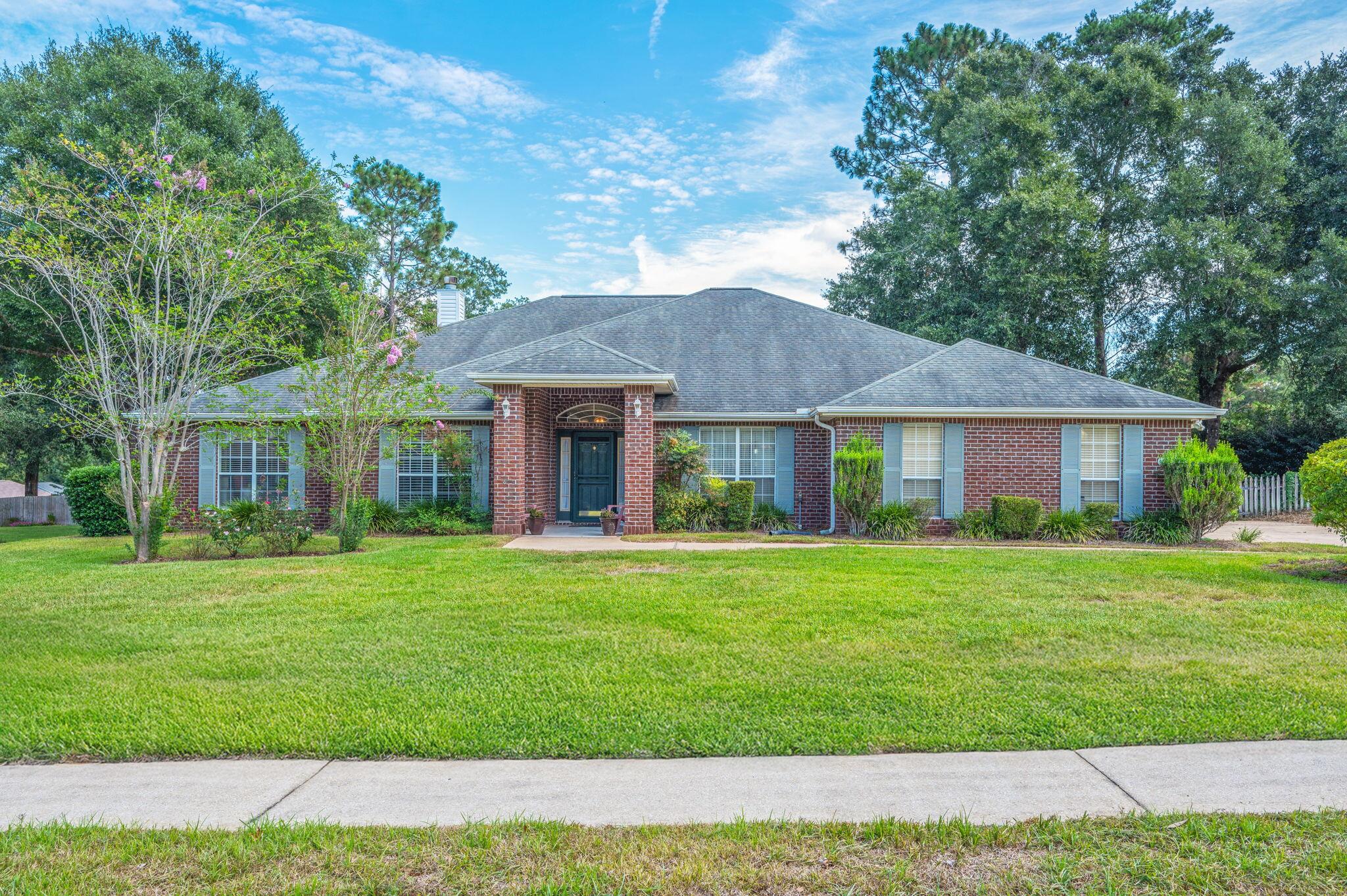 5863 Hunting Meadows Drive Crestview, FL 32536 - Photo 2 of 49 a front view of a house with a yard and trees