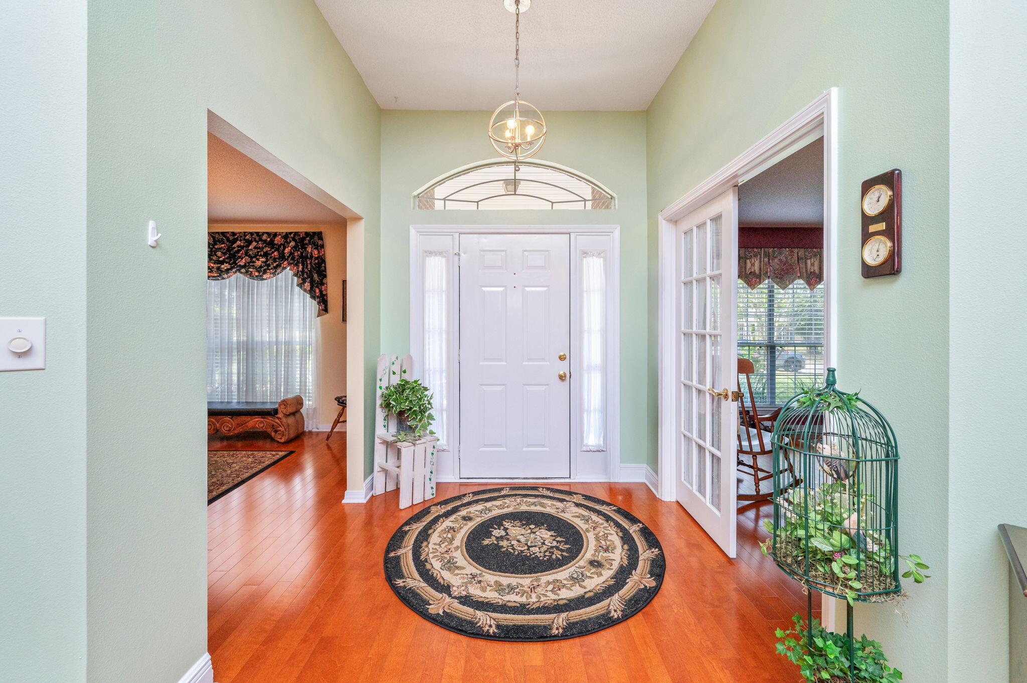 5863 Hunting Meadows Drive Crestview, FL 32536 - Photo 6 of 49 a view of a hallway with entryway wooden floor and a chandelier