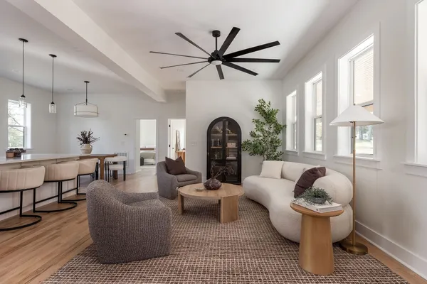 a kitchen with stainless steel appliances a sink a stove a refrigerator a center island and a wooden floor