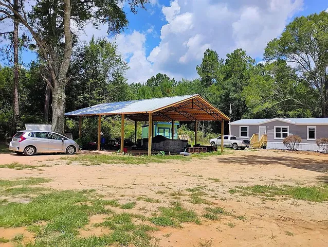 a view of a house with a yard and sitting area