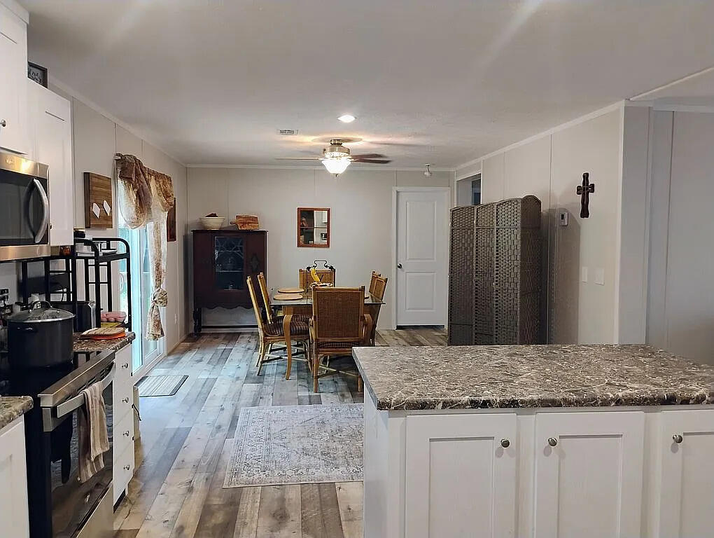 650 Satellite Road Graceville, FL 32440 - Photo 11 of 23 a kitchen with granite countertop kitchen island wooden cabinets and stainless steel appliances