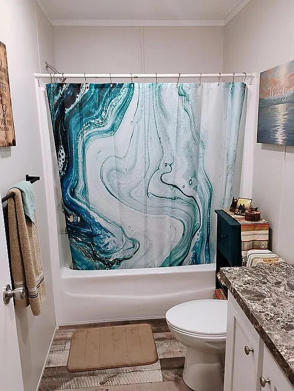 650 Satellite Road Graceville, FL 32440 - Photo 14 of 23 a bathroom with a granite countertop bathtub sink vanity mirror and toilet