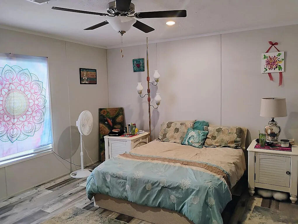 650 Satellite Road Graceville, FL 32440 - Photo 17 of 23 a bedroom with a bed and a painting on the wall