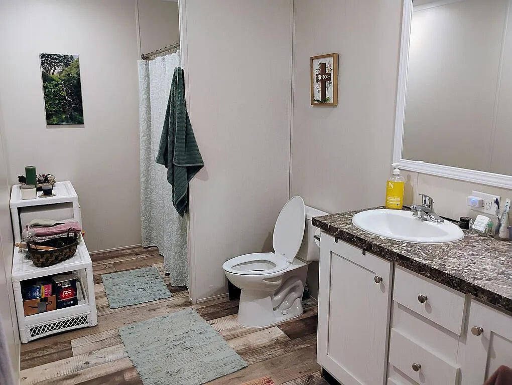 650 Satellite Road Graceville, FL 32440 - Photo 20 of 23 a bathroom with a granite countertop toilet sink and mirror