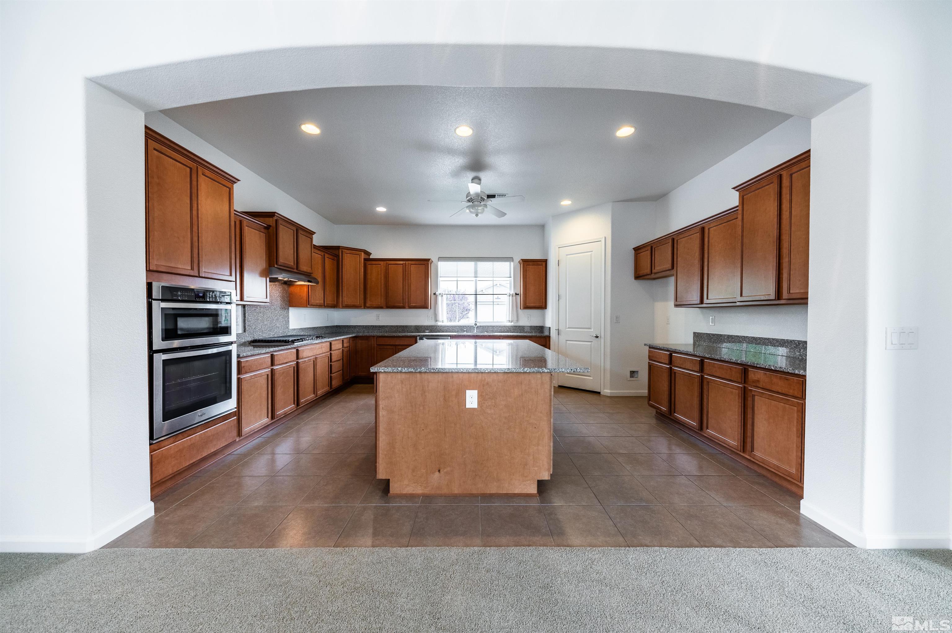 2305 Trakehner Lane Reno, NV 89521 - Photo 13 of 40 a large kitchen with stainless steel appliances kitchen island a large counter top and oven