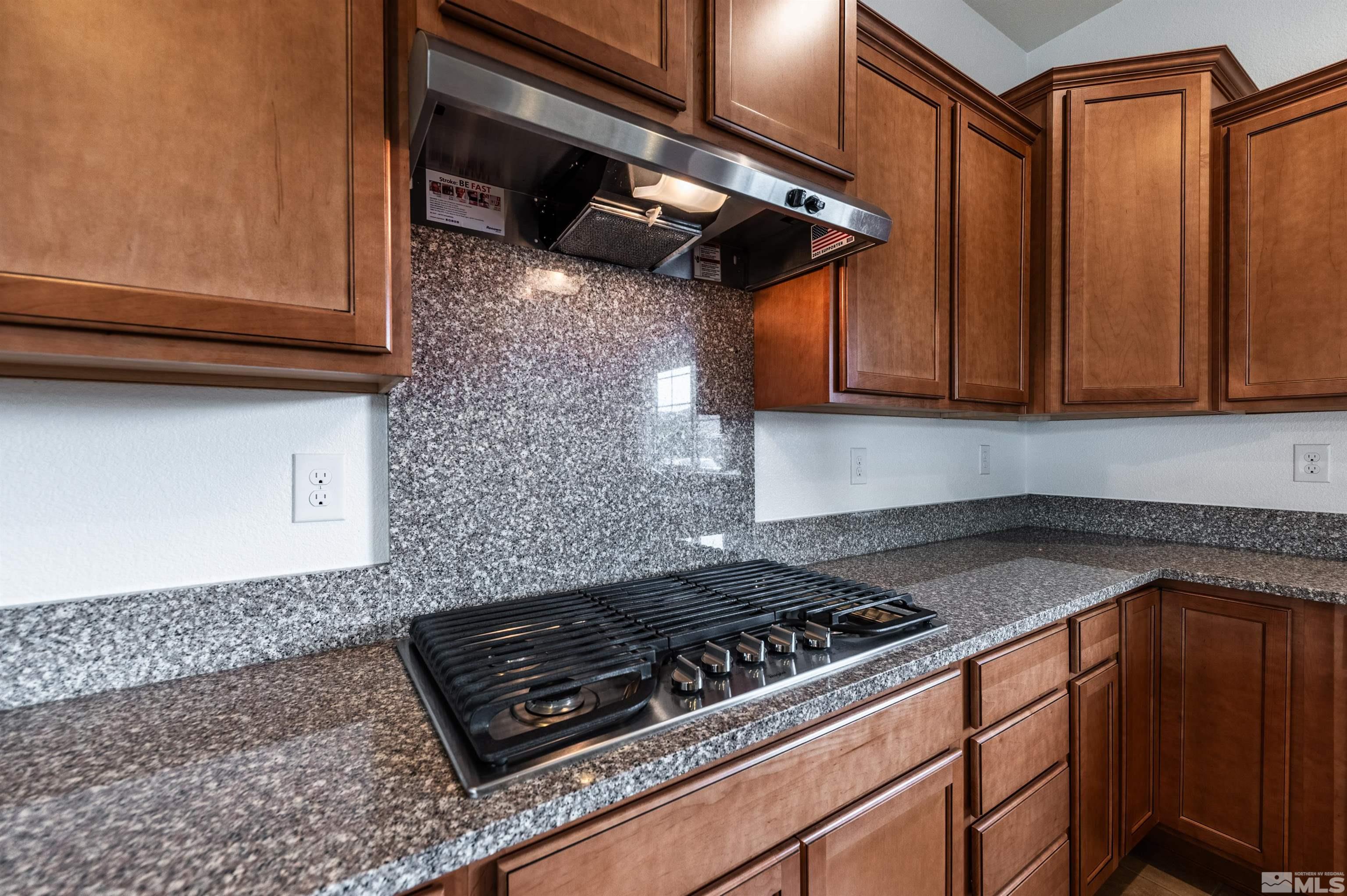 2305 Trakehner Lane Reno, NV 89521 - Photo 15 of 40 a kitchen with stainless steel appliances granite countertop a stove a sink dishwasher and cabinets
