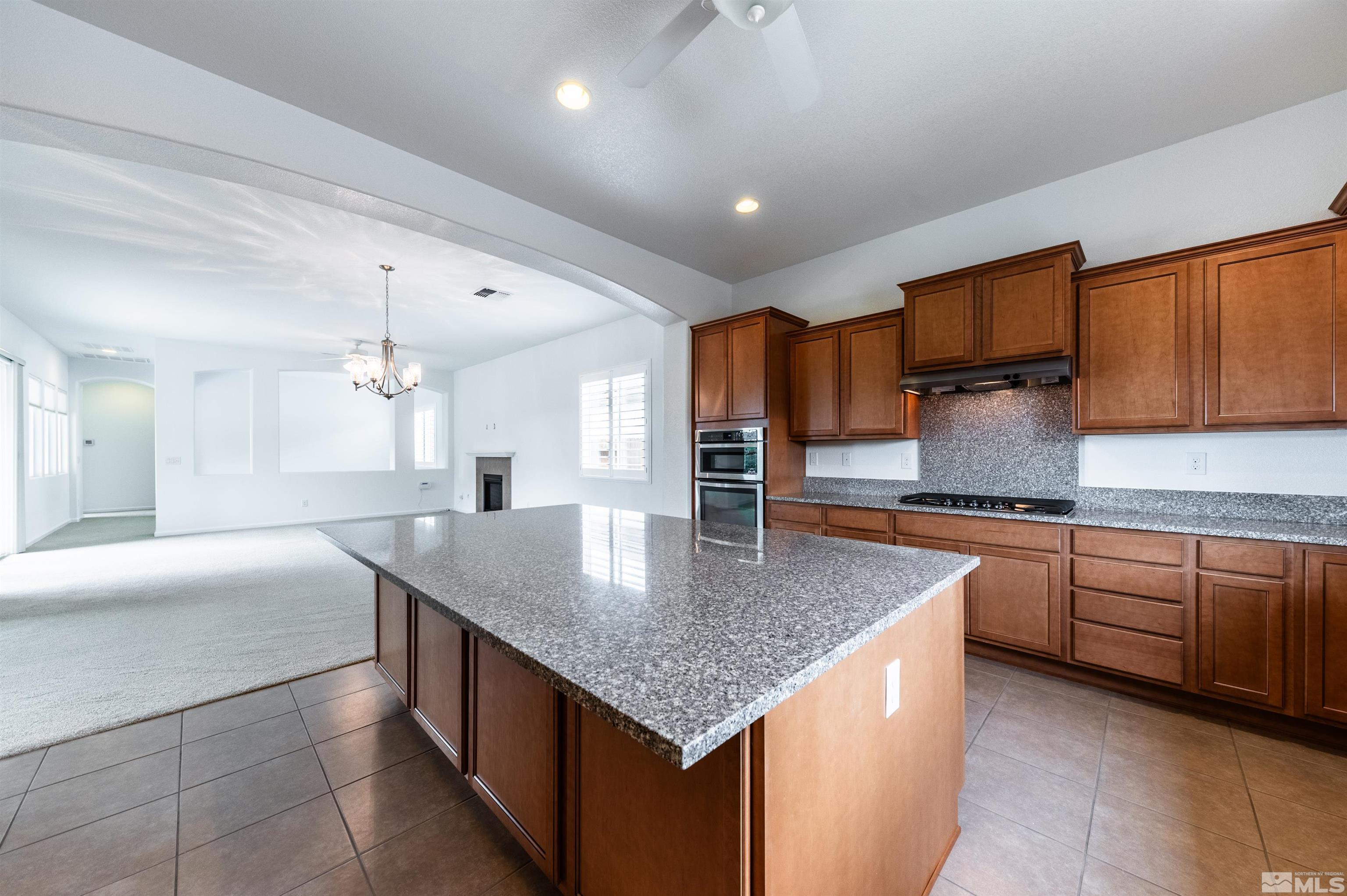 2305 Trakehner Lane Reno, NV 89521 - Photo 16 of 40 a kitchen with stainless steel appliances granite countertop a kitchen island a cabinets a sink and a refrigerator