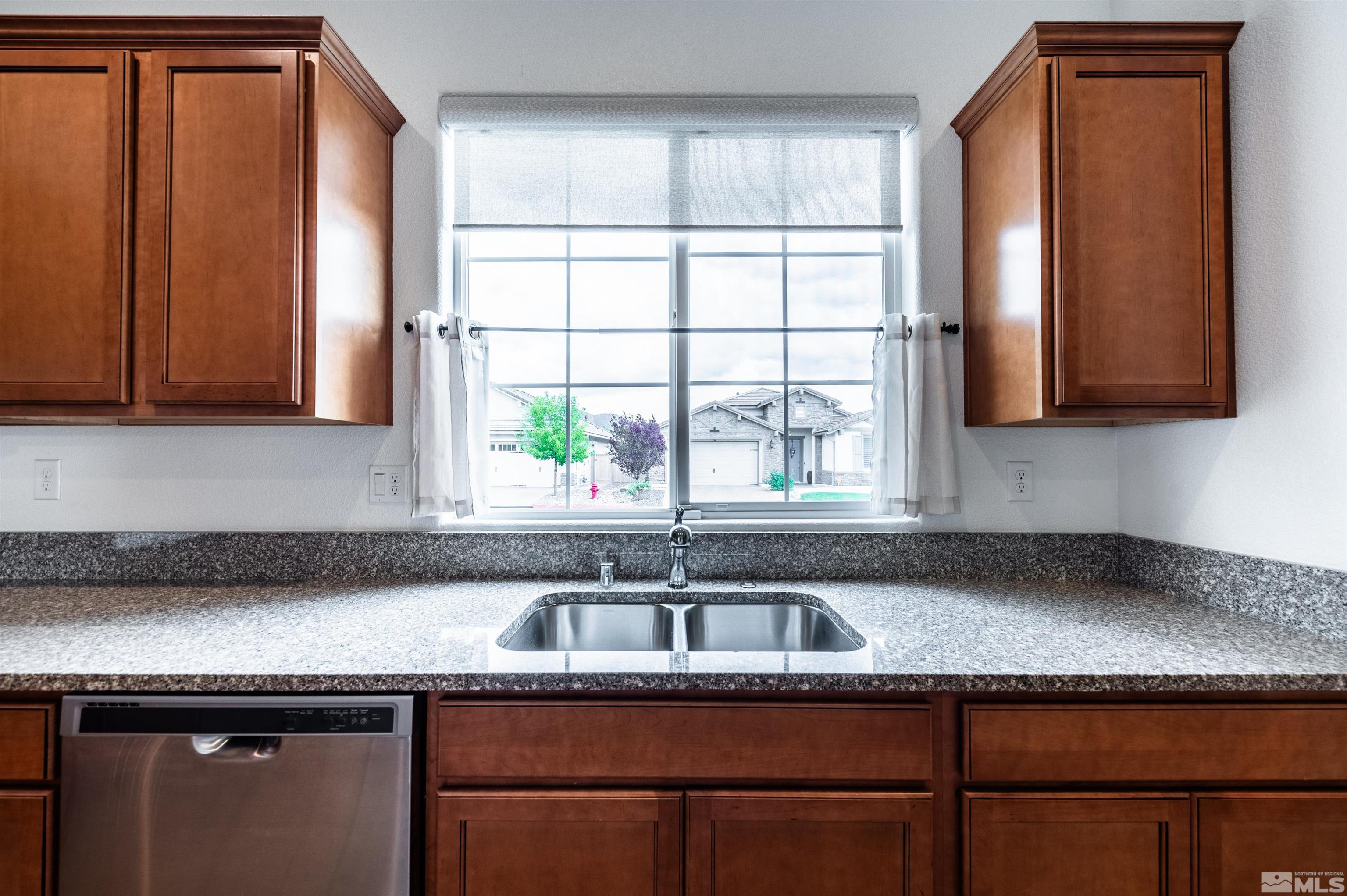2305 Trakehner Lane Reno, NV 89521 - Photo 17 of 40 a kitchen with granite countertop a sink a window and cabinets