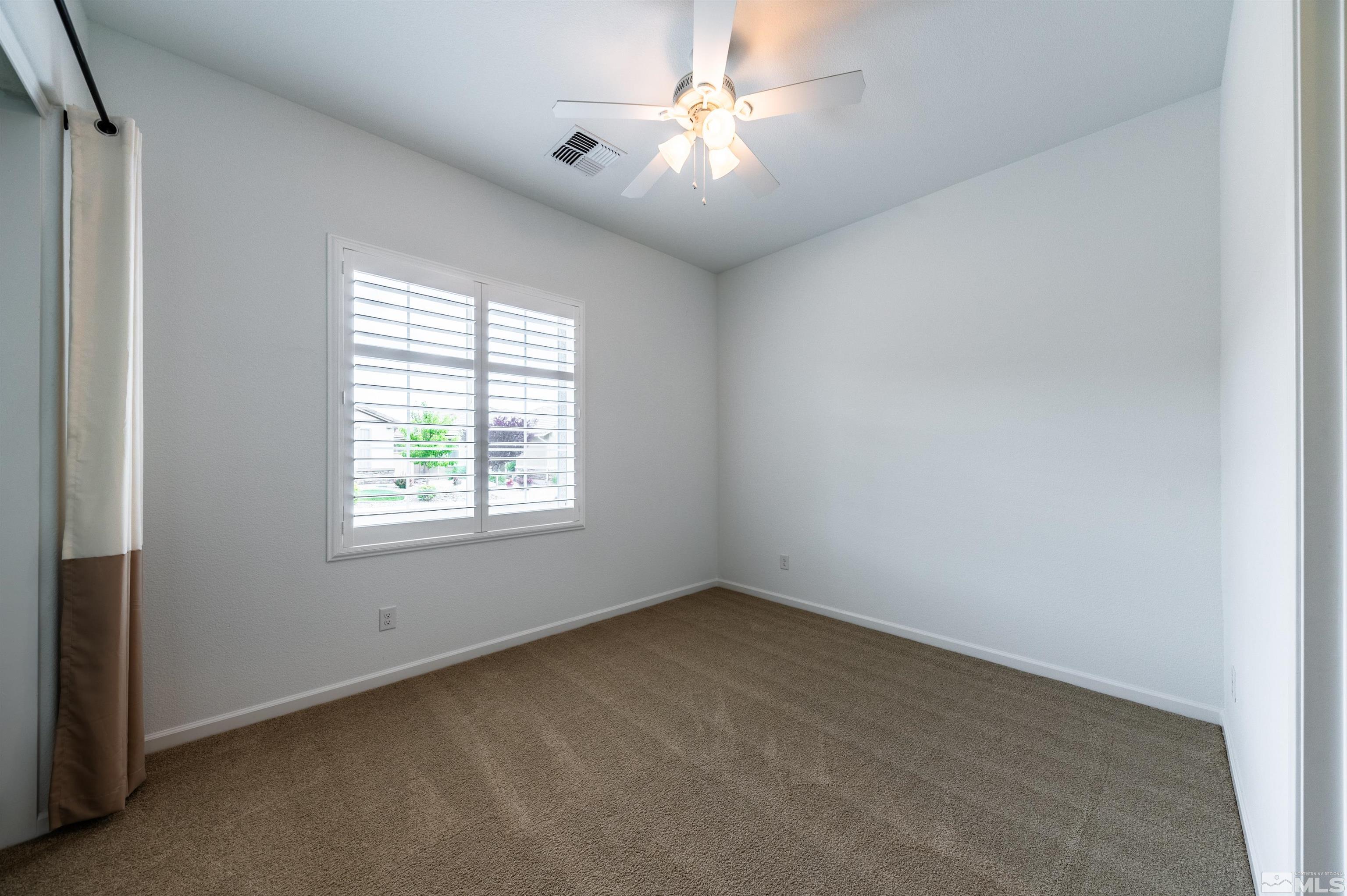 2305 Trakehner Lane Reno, NV 89521 - Photo 20 of 40 an empty room with a window and a fan