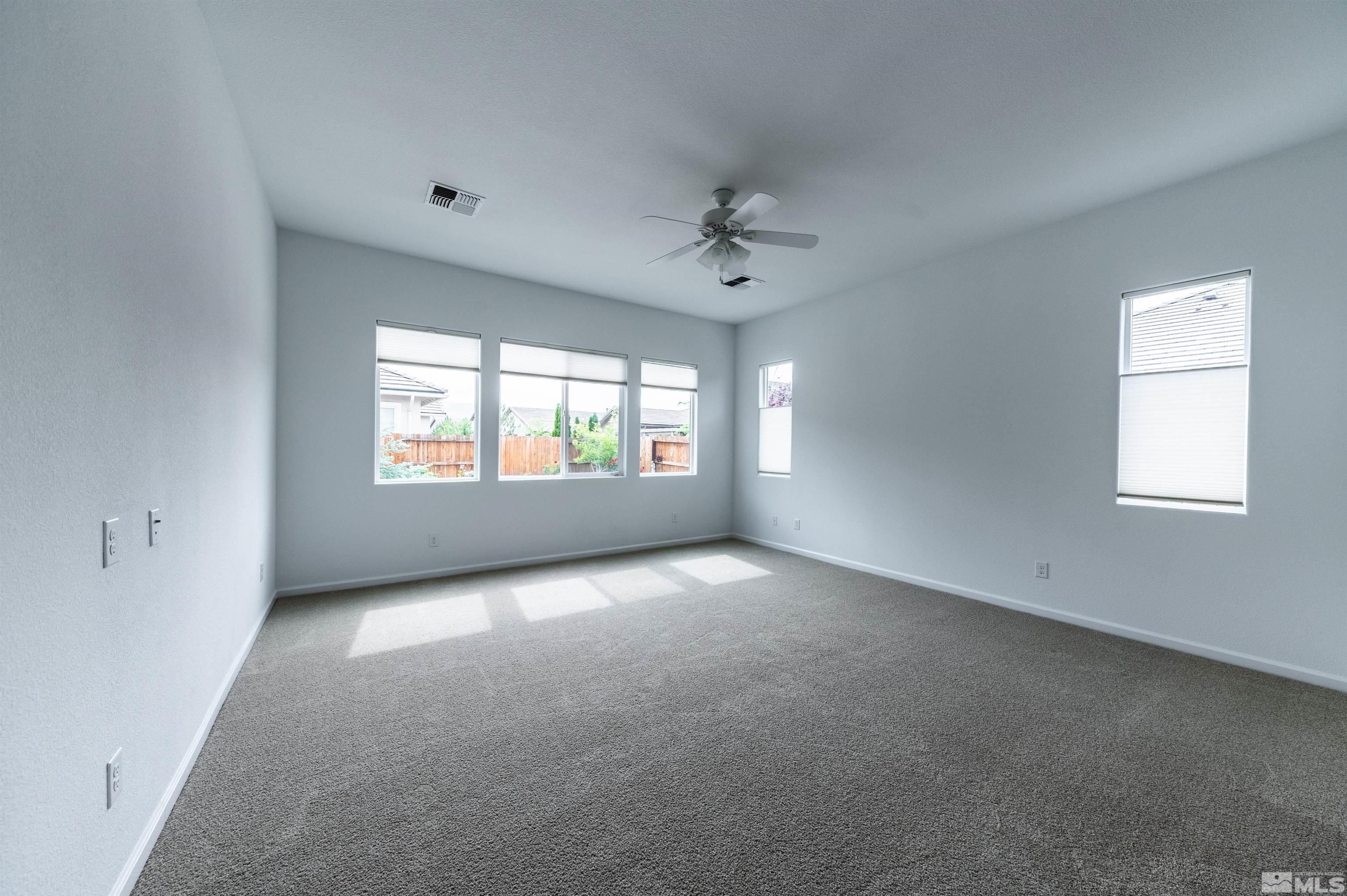 2305 Trakehner Lane Reno, NV 89521 - Photo 22 of 40 an empty room with windows and chandelier fan
