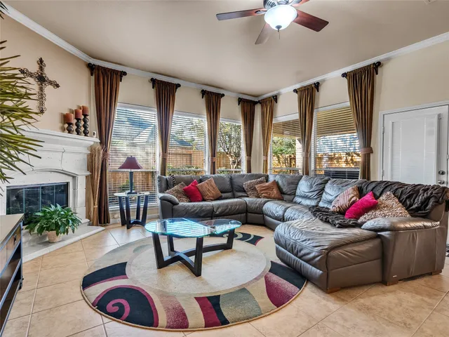 a living room with furniture a large window and a chandelier