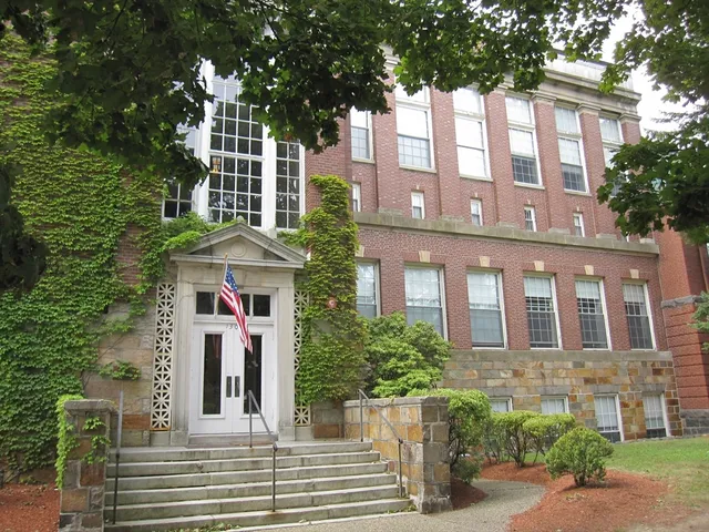 a front view of a multi story residential apartment building with a yard