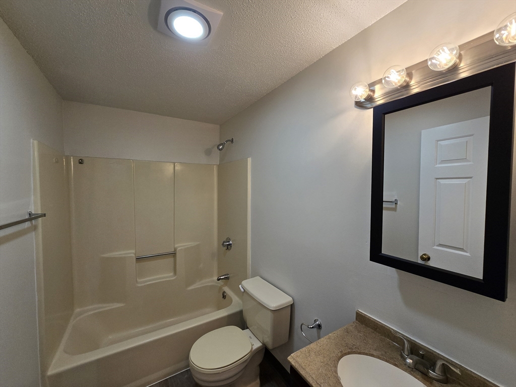 147 Rawson Road, Unit G3 Quincy, MA 02170 - Photo 11 of 20 a bathroom with a granite countertop toilet a sink and bathtub