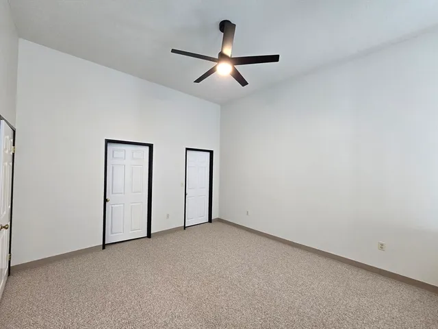an empty room with chandelier fan