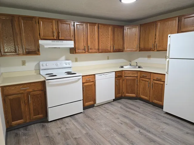 a kitchen with a white cabinets sink and white appliances