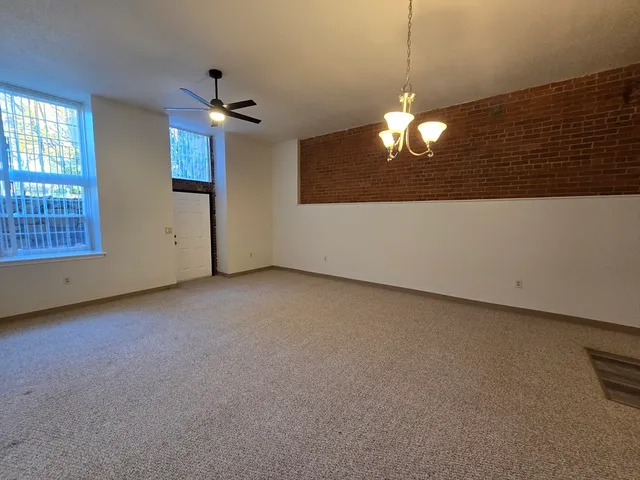 a view of a chandelier fan and windows in a room