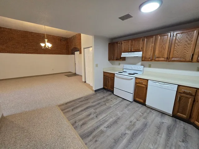 a kitchen with stainless steel appliances granite countertop a stove a sink and a refrigerator