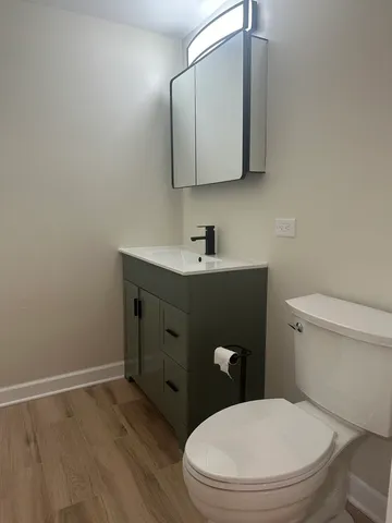 a bathroom with a toilet a sink and mirror