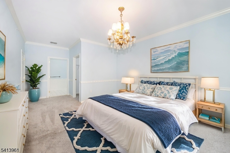 29 Ridgeview Lane, Unit 29 Mount Arlington, NJ 07856 - Photo 12 of 17 a bedroom with a bed and a chandelier