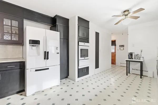 a kitchen with stainless steel appliances kitchen island granite countertop a refrigerator and a stove top oven