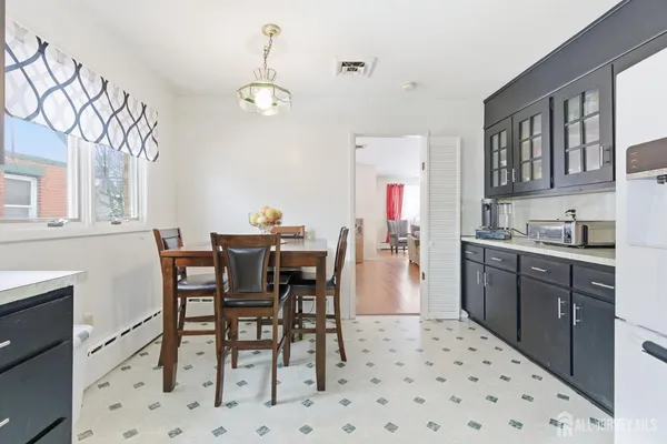 a kitchen with stainless steel appliances a dining table chairs and white cabinets