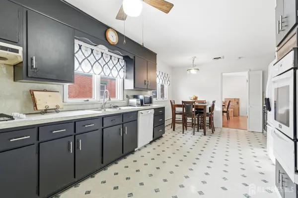 a kitchen with a sink and chairs