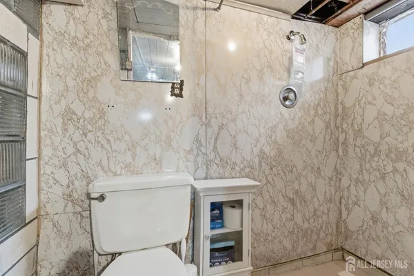 a bathroom with a toilet and a shower
