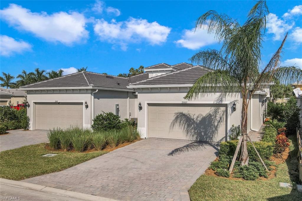 a view of a house with a yard and potted plants