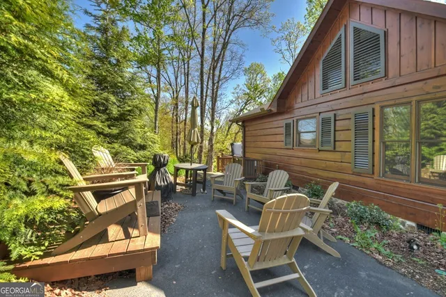 a view of backyard with large trees and wooden fence