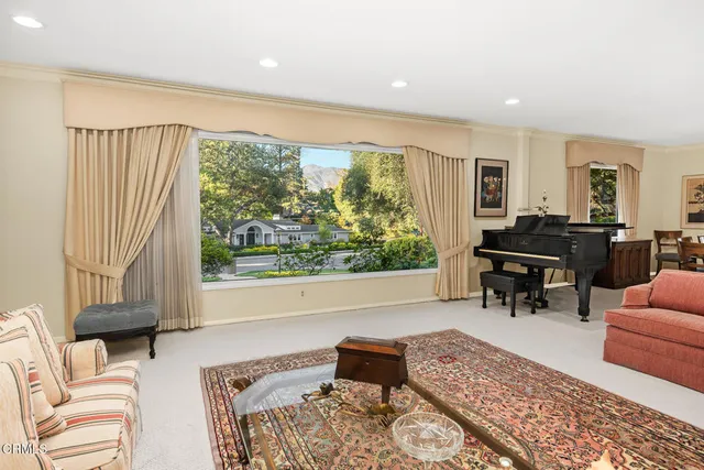 a dining room with wooden floor a chandelier a glass table and chairs