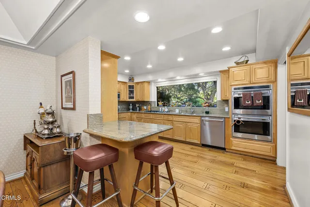 a view of a hallway with wooden floor and a bathroom