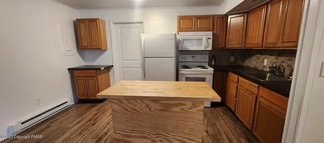 a kitchen with a refrigerator stove and wooden cabinets