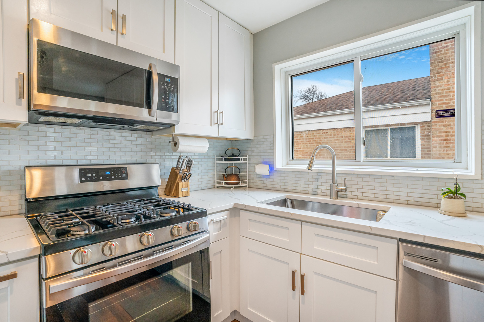 129 Rice Avenue Bellwood, IL 60104 - Photo 4 of 23 a kitchen with stainless steel appliances granite countertop white cabinets and a stove top oven