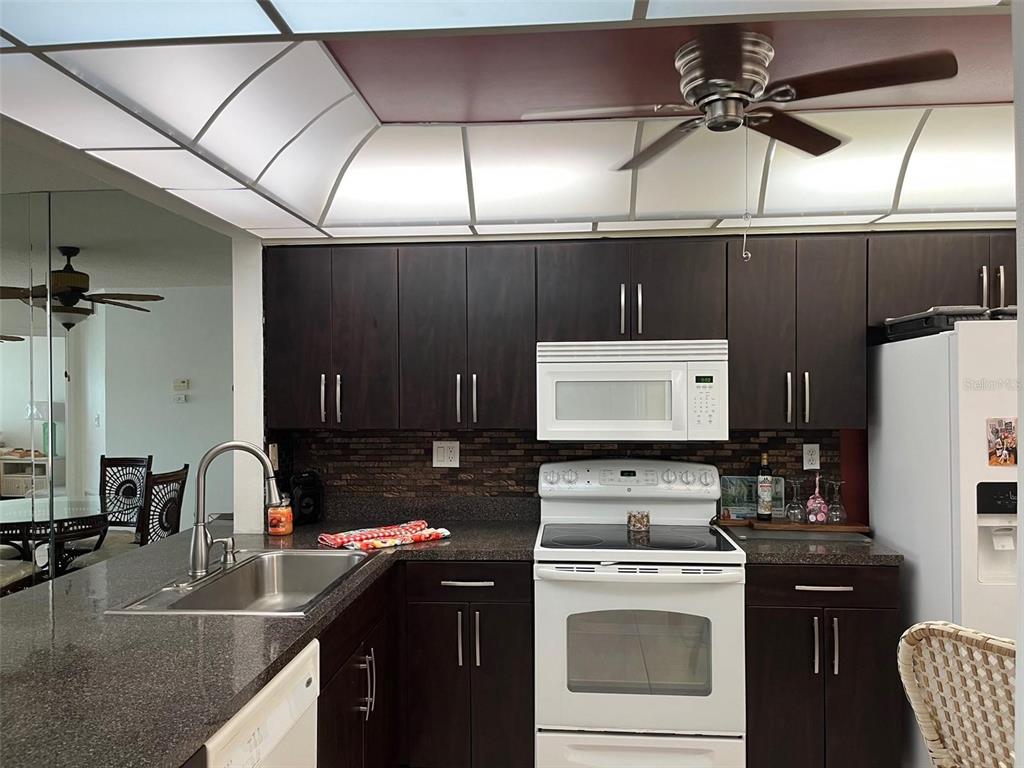 23465 Harbor View Road, Unit 1006 Punta Gorda, FL 33980 - Photo 12 of 36 a kitchen with a sink a stove and cabinets