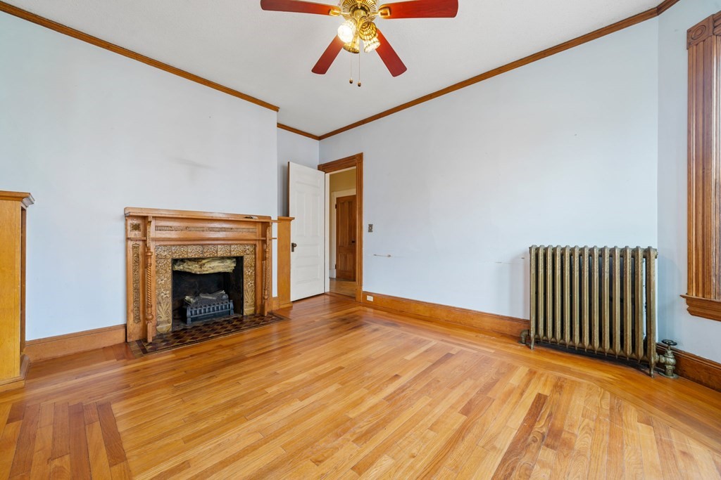 151 Lincoln Street Holyoke, MA 01040 - Photo 7 of 40 a view of empty room with fireplace and wooden floor