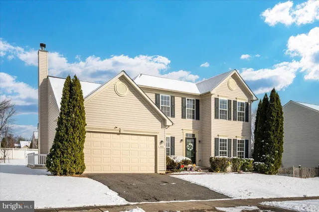 a view of a white house with a yard and potted plants