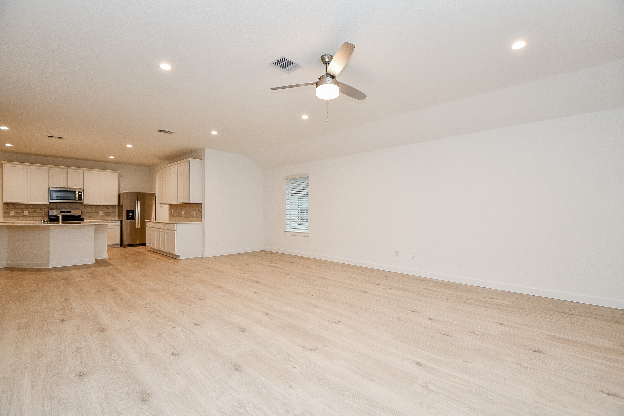 31715 Hallington Hl Lane Fulshear, TX 77441 - Photo 12 of 37 a view of an empty room with kitchen appliances and a ceiling fan