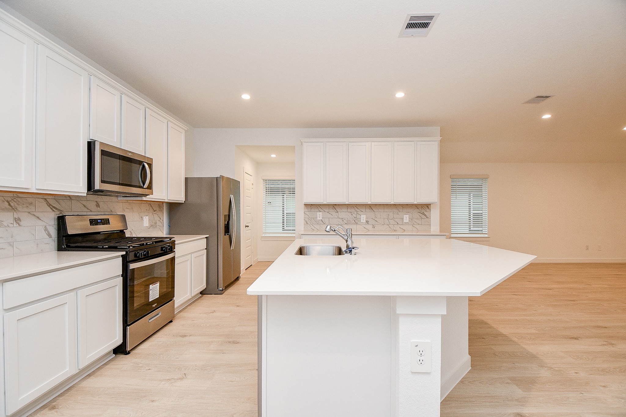 31715 Hallington Hl Lane Fulshear, TX 77441 - Photo 4 of 37 a kitchen with a sink a stove top oven and refrigerator