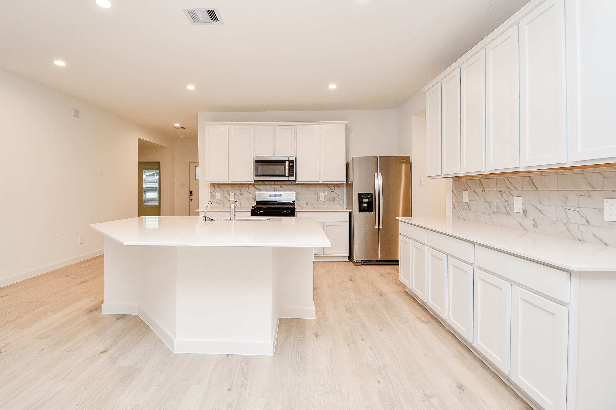 31715 Hallington Hl Lane Fulshear, TX 77441 - Photo 6 of 37 a kitchen with stainless steel appliances a refrigerator stove microwave and sink