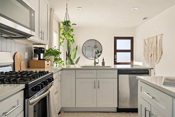 a kitchen with stainless steel appliances granite countertop a stove a sink and a window