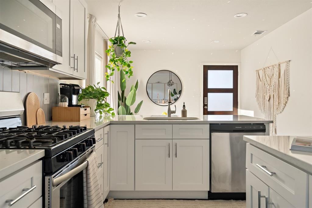 a kitchen with stainless steel appliances granite countertop a stove a sink and a window