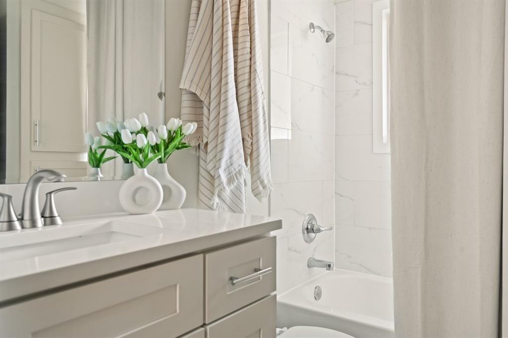 6003 Jain Lane, Unit A Austin, TX 78721 - Photo 14 of 15 a bathroom with a granite countertop sink a mirror and a bathtub