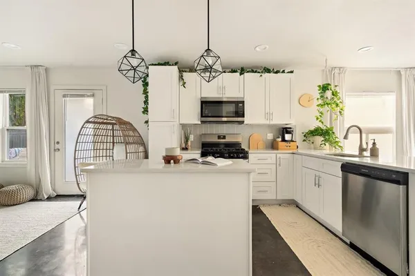 a kitchen with stainless steel appliances granite countertop a microwave a stove and a sink