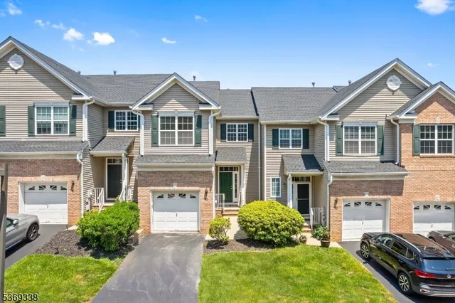 a front view of a house with a yard and potted plants