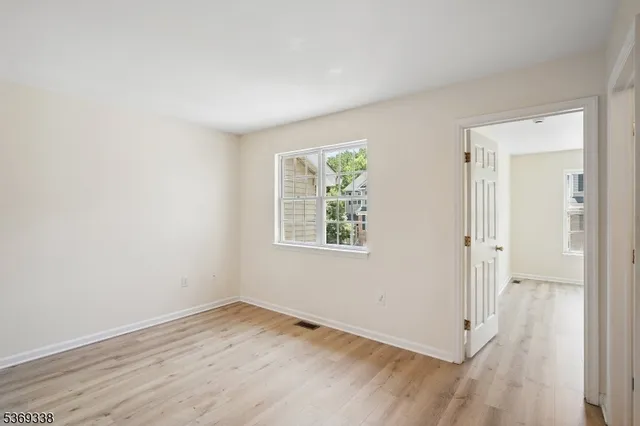 an empty room with wooden floor and window