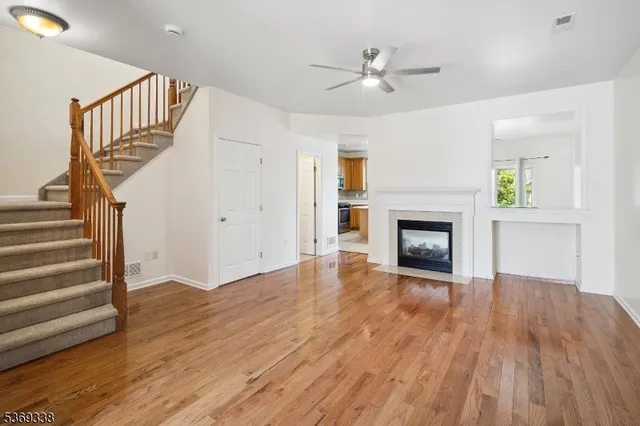a view of an empty room wooden floor and a fireplace