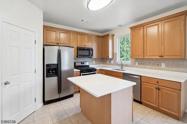 a kitchen with a refrigerator sink and cabinets